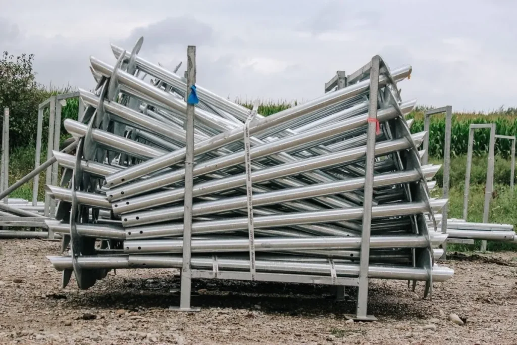 A stack of galvanized screw piles neatly arranged at a construction site, ready for installation in various projects.